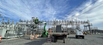 Worker inspecting high voltage cables.